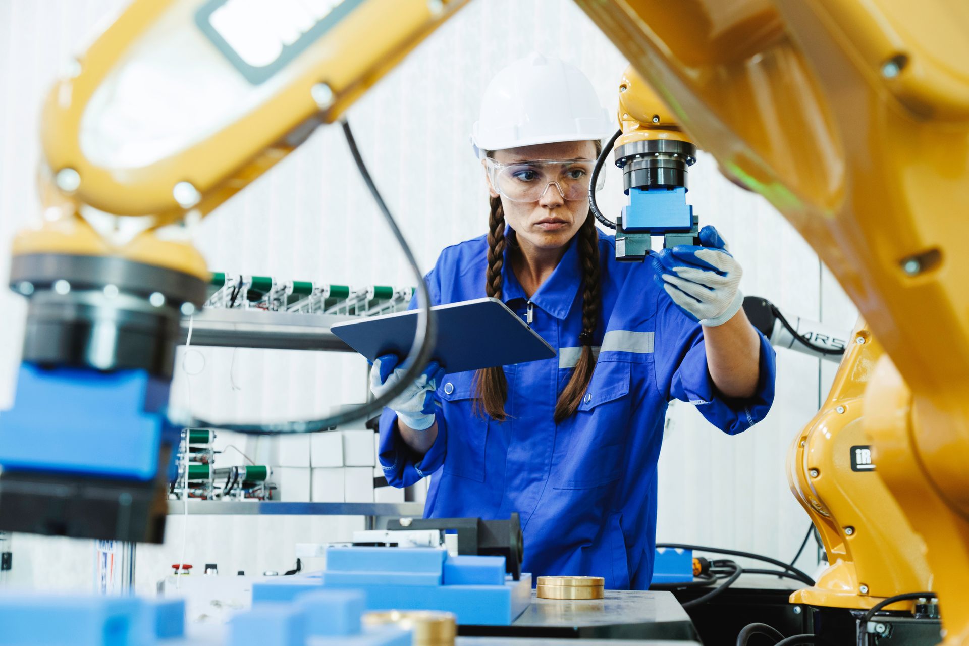 An engineer working alongside a robotic arm