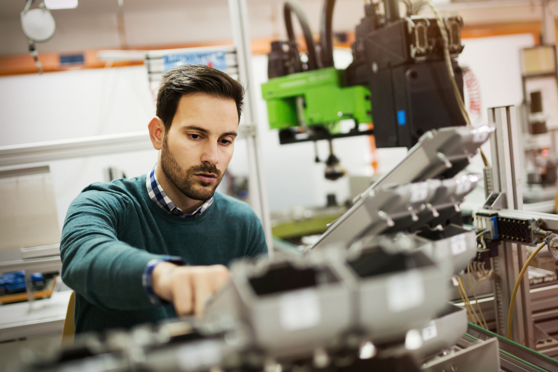 Engineer working on industrial automation hardware in a manufacturing facility