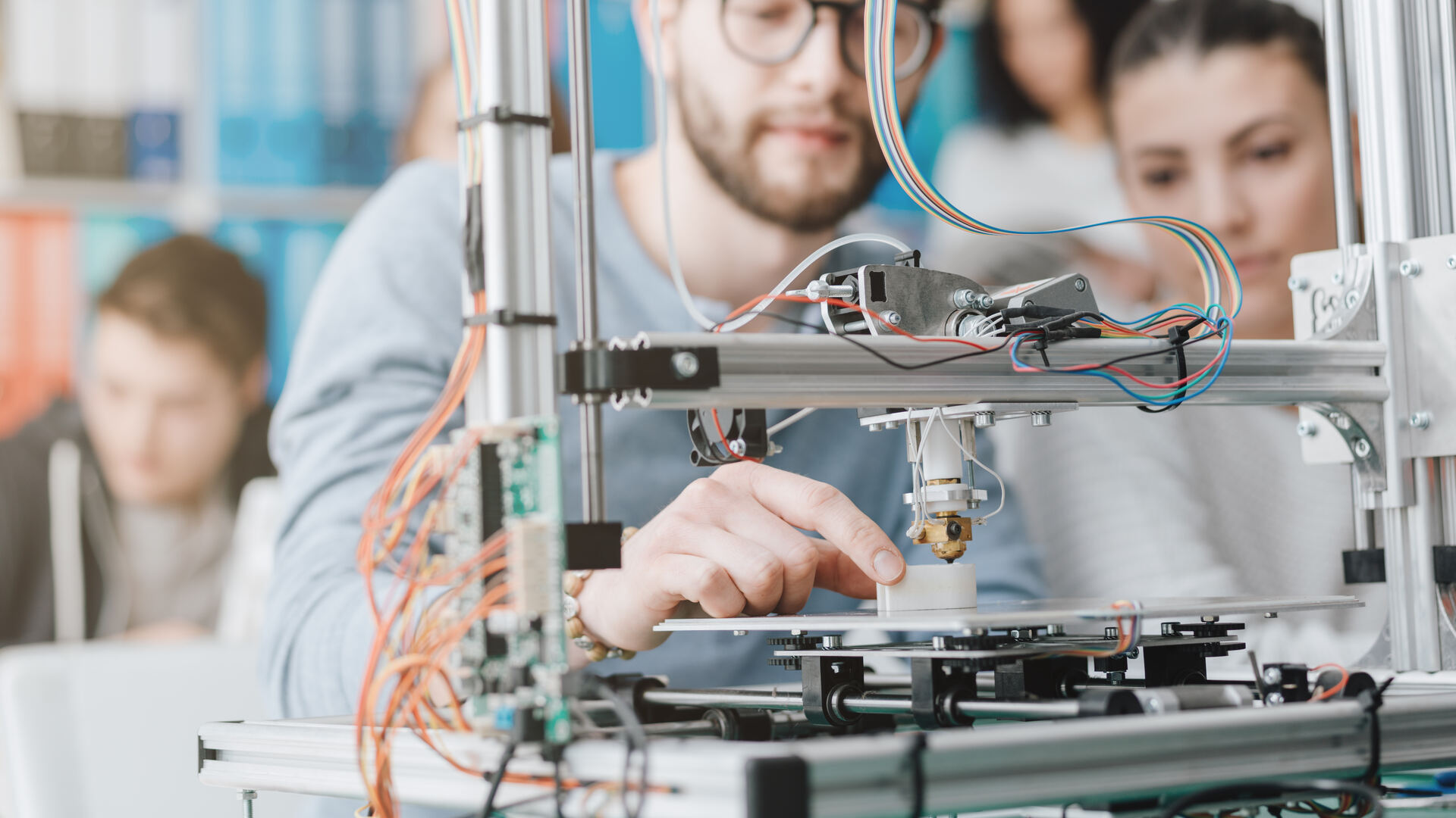 Engineering team working with 3D printing equipment in a collaborative lab environment