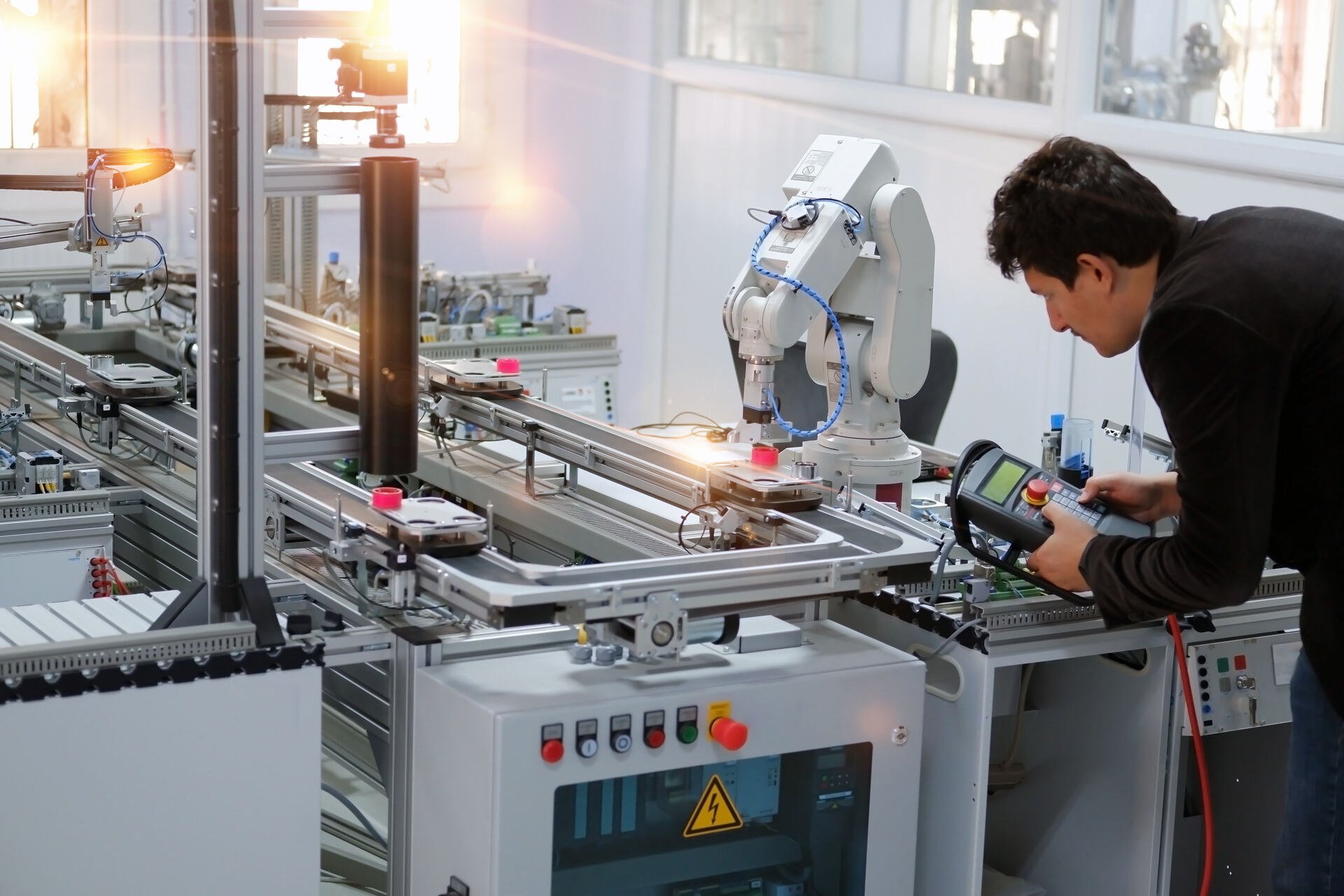 Engineer using a controller to operate an automated test system on a production line